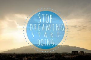 text reading "stop dreaming start doing" on a blue circle over a sunset